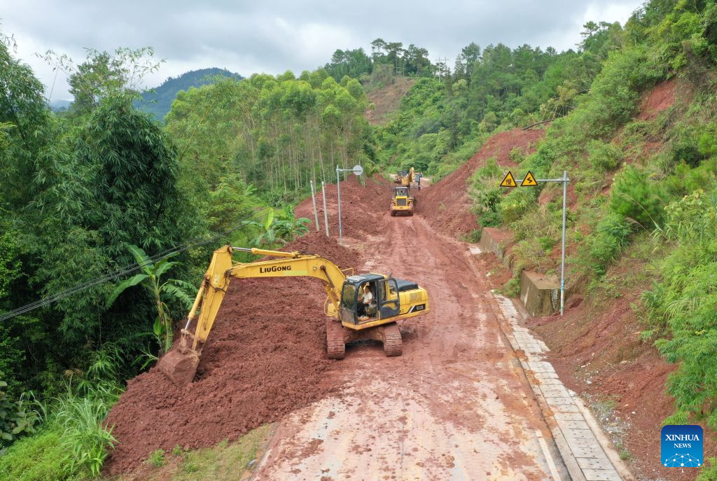 An aerial drone photo taken on Aug. 26, 2026 shows workers repairing a road section interrupted by a landslide in Tongmian Town of Ningming County, Chongzuo City, south China's Guangxi Zhuang Autonomous Region. Continuous heavy rainfall caused by Typhoon Narra, the 19th typhoon of the year, has swept across Ningming County. Local authorities have taken every efforts to clear, repair and reinforce the damaged roads and bridges. (Xinhua/Lu Boan)