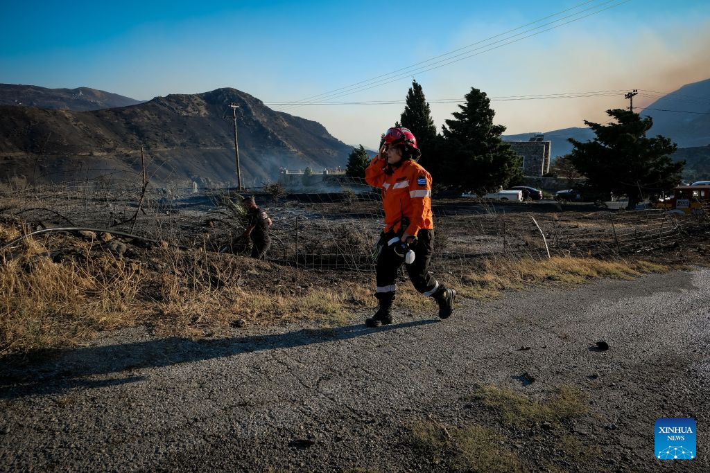 A firefighter takes part in firefighting operations in Rethymno on the island of Crete, Greece, July 29, 2026. Two firefighters lost their lives while battling a fast-moving wildfire in Rethymno on the Greek island of Crete on Wednesday, as gale-force winds fueled the blaze across a front stretching more than 15 kilometers. (Photo by Rapanis Spiros/Xinhua)