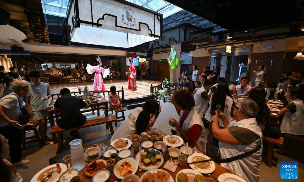 Tourists enjoy Laobacha dishes and Qiong Opera performance at a teahouse in Haikou, south China's Hainan Province, July 19, 2026. Hainan is seeing a surge in visitors during the summer holiday season. (Xinhua/Guo Cheng)