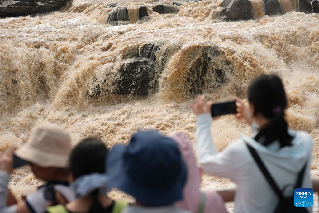 Tourists visit the Yellow River's Hukou Waterfall in northwest China's Shaanxi Province, Aug. 10, 2026. (Xinhua/Shao Rui)