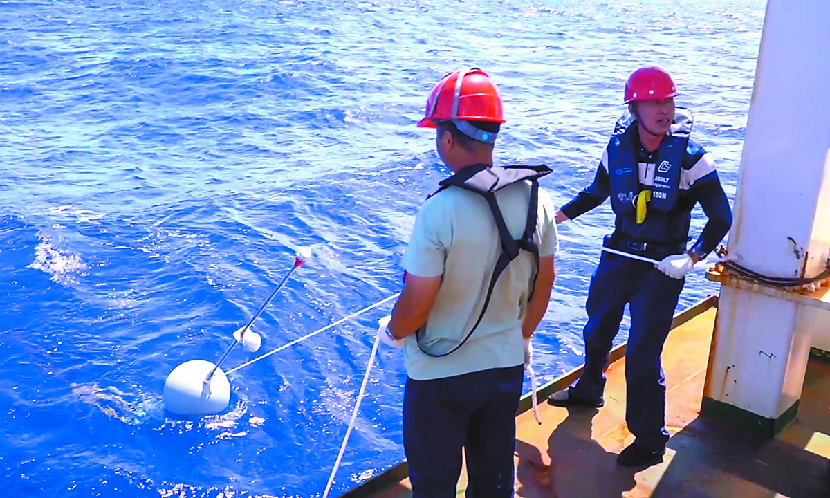 Researchers aboard Xiangyanghong 22 deploy survey equipment during a marine environmental survey operation. Photo: Courtesy of Wang Yuerui
