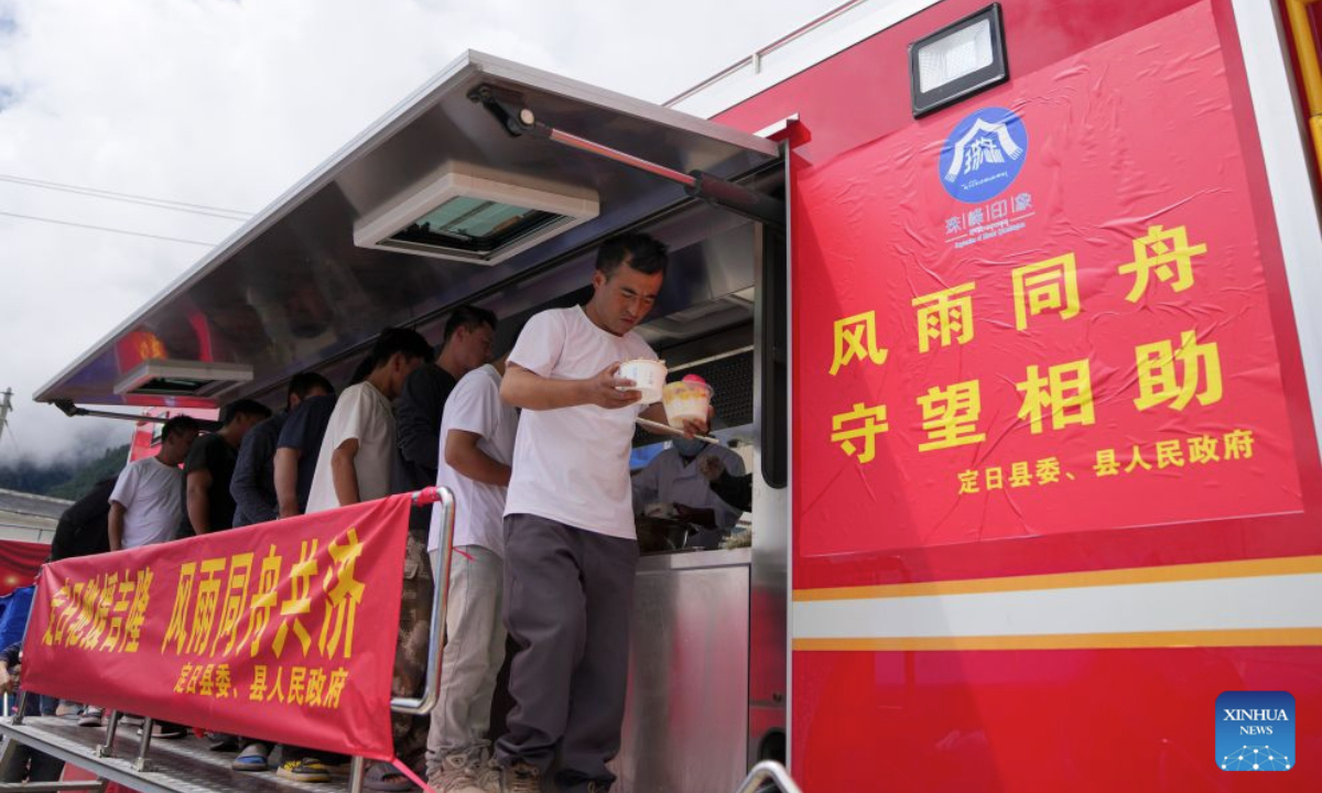 Rescue workers receive lunches from a food truck in mudslide-affected Gyirong Town, southwest China's Xizang Autonomous Region, Aug. 31, 2026.
A food truck has been deployed in mudslide-affected Gyirong Town of Gyirong County recently, providing hot meals to disaster relief volunteers. The truck came from the neighboring Tingri County. After being hit by an earthquake in 2025, Tingri County purchased the truck with funds from east China's Shanghai under an assistance program for Xizang. After Gyirong Town was hit by the mudslide, Tingri County soon dispatched the truck to share mobile food services for disaster relief. (Xinhua/Jigme Dorje)
