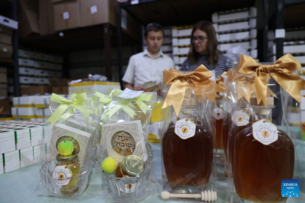 Shoppers select honey at a honey shop in Kfar Chabad near Tel Aviv, Israel, Sept. 8, 2026. Apple slices dipped in honey are traditionally eaten during Rosh Hashanah to symbolize wishes for a sweet new year. Rosh Hashanah, the Jewish New Year, will begin at sunset on Sept. 11. (Photo by Gil Cohen Magen/Xinhua)