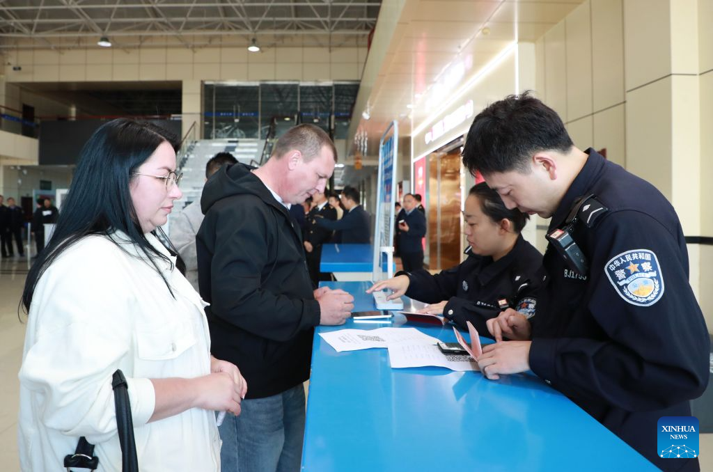 Police officers of Heihe border inspection station help foreign passengers fill out foreigner arrival cards at a port in Heihe, northeast China's Heilongjiang Province, Sept. 14, 2026. Cross-border personnel exchanges at the Heihe Port are getting more and more active since the implementation of the visa-free policy between China and Russia. The number of inbound and outbound passenger trips through the port since the beginning of 2026 has hit a record high of 1 million until Monday, an increase of 56.18 percent year on year. (Photo by Liu Song/Xinhua)