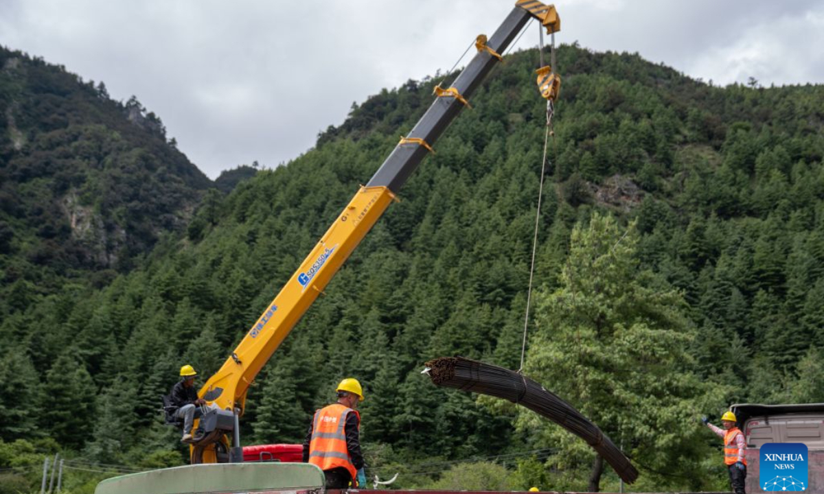 Workers from China Railway Group Limited unload steel bars at a temporary processing site in Gyirong County, southwest China's Xizang Autonomous Region, Aug. 30, 2026. Workers from China Railway Group Limited stepped up efforts on Sunday to make steel-reinforced gabion baskets to support the restoration of road access to mudslide-hit areas in Gyirong County for rescue operations. (Xinhua/Jiang Fan)