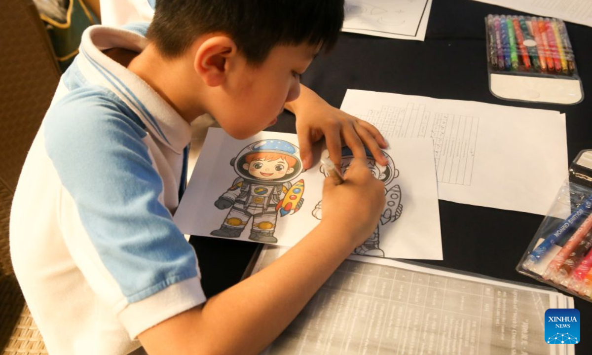A child takes part in a coloring activity during the opening ceremony of the Weekly Cinema, Shared Stories Film Exhibition at the National Theater in Yangon, Myanmar, Aug. 9, 2026. (Xinhua/Myo Kyaw Soe)