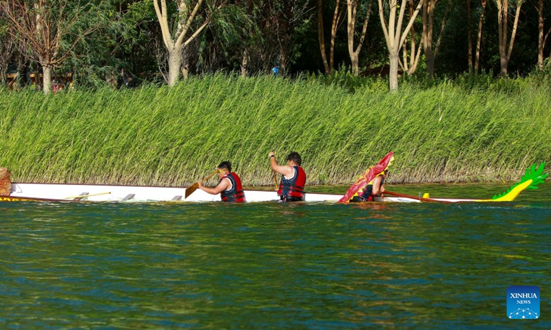 Anwar Kurban (R) and his teammates compete during the 2026 dragon boat race on Hongyan River in Korla City, northwest China's Xinjiang Uygur Autonomous Region, June 20, 2026.