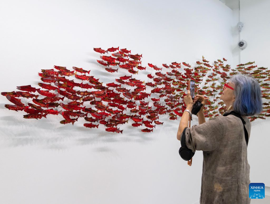 A visitor films artworks on display at the World of Threads Festival 2026 in Oakville, Ontario, Canada, on Sept. 28, 2026. Showcasing contemporary fibre and textile art in all forms from around the world, the event will last till Jan. 17, 2027. (Photo by Zou Zheng/Xinhua)