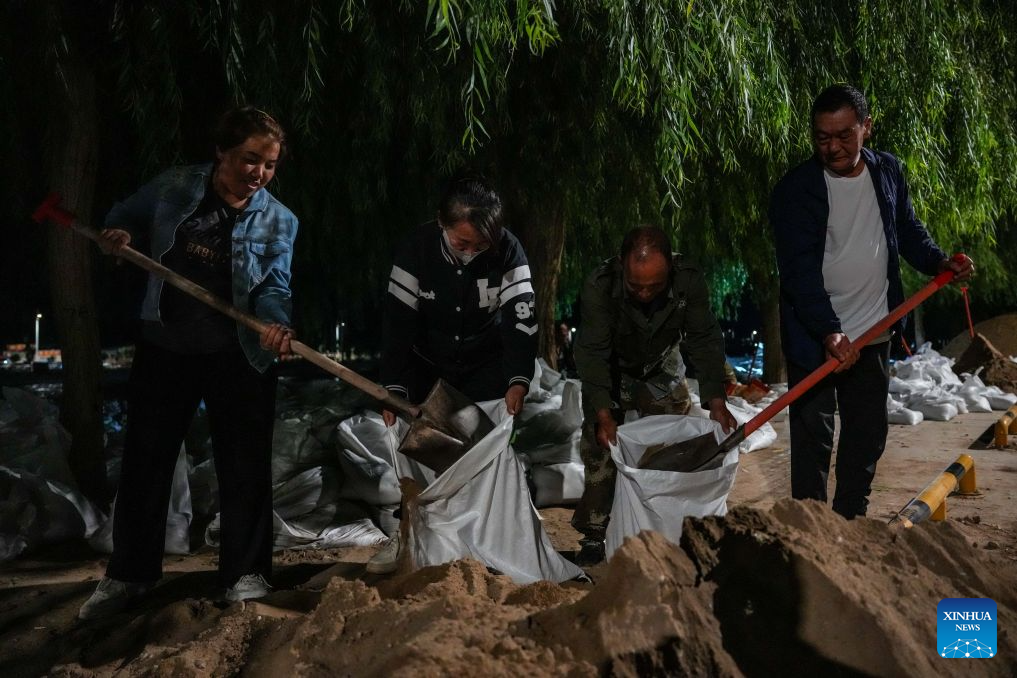 Local officials and residents stack sandbags to fortify the embankment along the Danghe River in Dunhuang, northwest China's Gansu Province, July 29, 2026. The water level of the Danghe River, which runs through Dunhuang City in northwest China's Gansu Province, rose rapidly following days of heavy rainfall and increased inflows from upstream. Local personnel in Dunhuang quickly mobilized for flood control and relief operations. (Xinhua/Lang Bingbing)