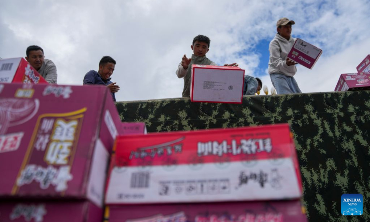People unload instant noodles from a vehicle in Gyirong Town of Gyirong County, Xigaze City, southwest China's Xizang Autonomous Region, Aug. 27, 2026. Six vehicles loaded with relief supplies, including instant noodles, rice, flour, mineral water and other daily necessities, arrived in Gyirong Town on Thursday afternoon. (Xinhua/Jigme Dorje)