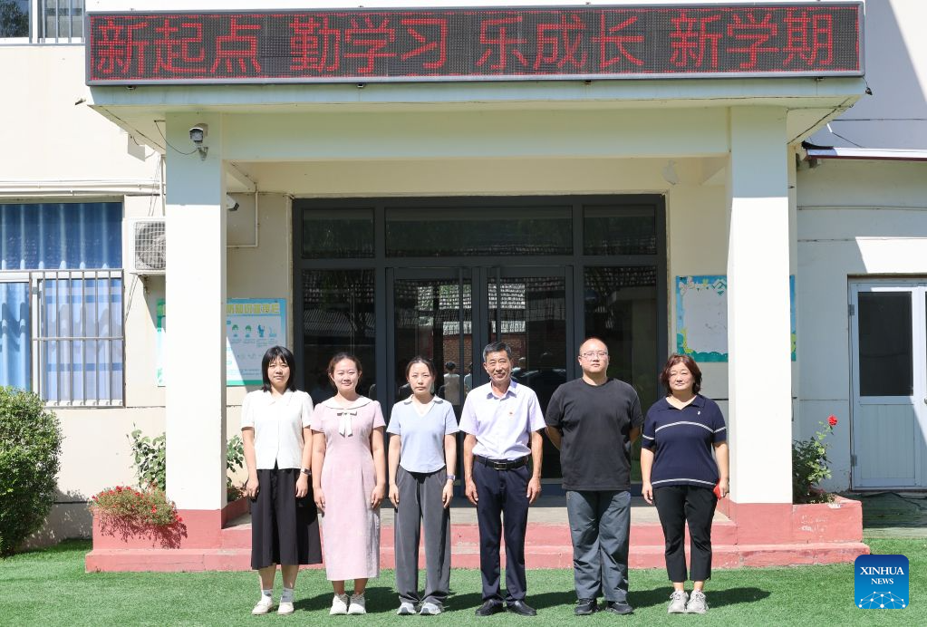 Zheng Baoguo (3rd R) poses for a group photo with colleagues in Luozhuangzi Town of Jizhou District in Tianjin, north China, on Sept. 3, 2026.

The Sangyuan campus of Hongshuizhuang Central Primary School is located at the foot of the Yanshan Mountains in Jizhou District. The small rural school has just 28 students and serves three neighboring villages. It allows local children to attend classes close to home rather than travel nearly 10 kilometers to the town's central primary school.

Zheng Baoguo, 56 and a native of Jizhou District, has worked at the school for more than 20 years. After graduating from a secondary normal school in 1989, he became a rural teacher. He has long believed that education is a key to a brighter future for children in mountainous areas.

In 2003, Zheng became the first principal of the Sangyuan campus. Although he later had an opportunity to work in an urban school, he chose to stay and continue his career in his hometown. More than two decades later, Zheng still teaches classes himself despite serving as principal, and he always creates a relaxed and cheerful atmosphere for his students.

A teacher can change a child's life. As a teacher, I must live up to families' trust, Zheng said, As long as the school remains open, I will keep doing my best to ensure that children in these mountain villages have access to education close to home. (Xinhua/Li Ran)