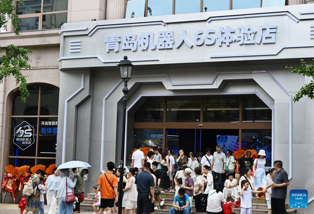 People visit a robot 6S experience store in Qingdao, east China's Shandong Province on Aug. 11, 2026. Recently, the first robot 6S experience store in Qingdao opened, attracting a large number of consumers to visit and experience. This store integrates six major functions including sale, spare parts, service, survey, lease and personalized customization, helping further introducing robots into people's lives. (Xinhua/Li Ziheng)