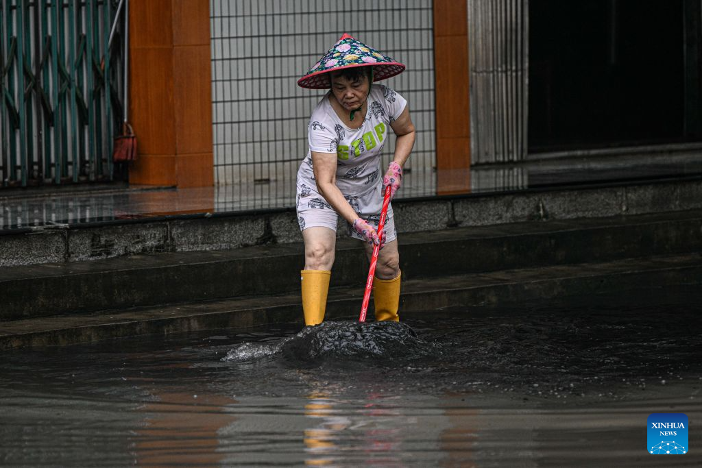 A resident cleans up silt from a road in Qionghai, south China's Hainan Province, Sept. 14, 2026. As the intensity and extent of torrential rainfall decreased, Hainan has shifted to full-scale post-disaster recovery operations across the province. (Xinhua/Pu Xiaoxu)