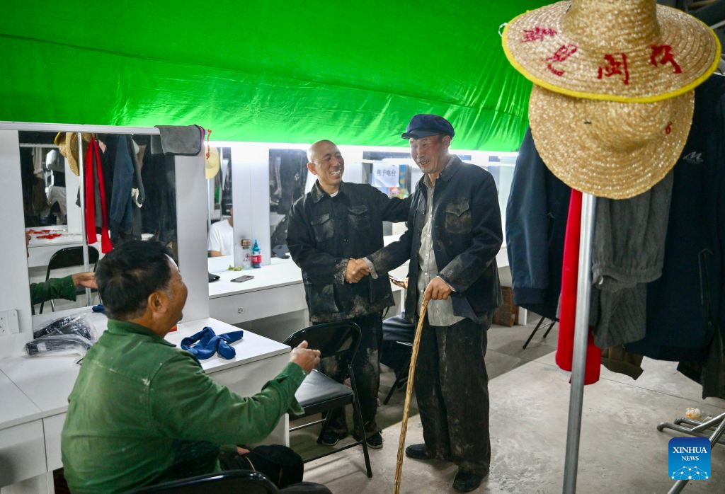 Farmer-actor Wang Guozhong (R) chats with fellow villager-actors in the actors' lounge at the theater village in Minning Town of Yinchuan, northwest China's Ningxia Hui Autonomous Region, Sept. 11, 2026.
This year marks the 30th anniversary of paired assistance initiative between southeast China's Fujian Province and northwest China's Ningxia Hui Autonomous Region for targeted poverty alleviation.
A new theater village cultural tourism project has been launched in Minning Town of Yinchuan to commemorate the past three decades of Fujian-Ningxia cooperation. A total of 36 original plays recount the continuous efforts of anti-poverty by Ningxia with help from Fujian over the past 30 years.
Since the project opened in July this year, it has helped 2,500 local residents nearby secure jobs and increase their incomes. (Xinhua/Yang Zhisen)