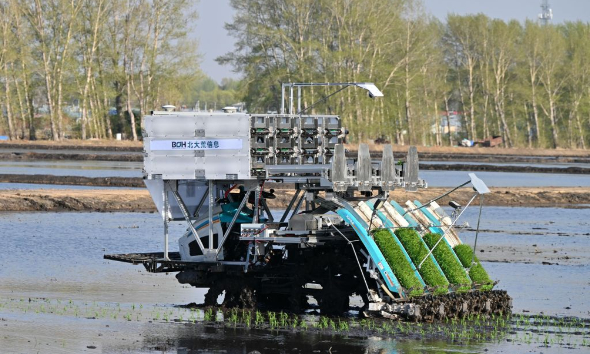 An unmanned machinery transplants rice seedlings in a field of a farming company under Beidahuang Group in northeast China's Heilongjiang Province, May 11, 2026. (Photo by Wang Xue/Xinhua)