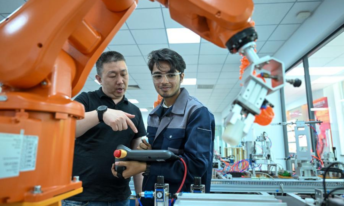 A teacher gives operating instructions to a student at the Luban Workshop of Tianjin Modern Vocational Technology College in north China's Tianjin, June 16, 2025. (Xinhua/Sun Fanyue)