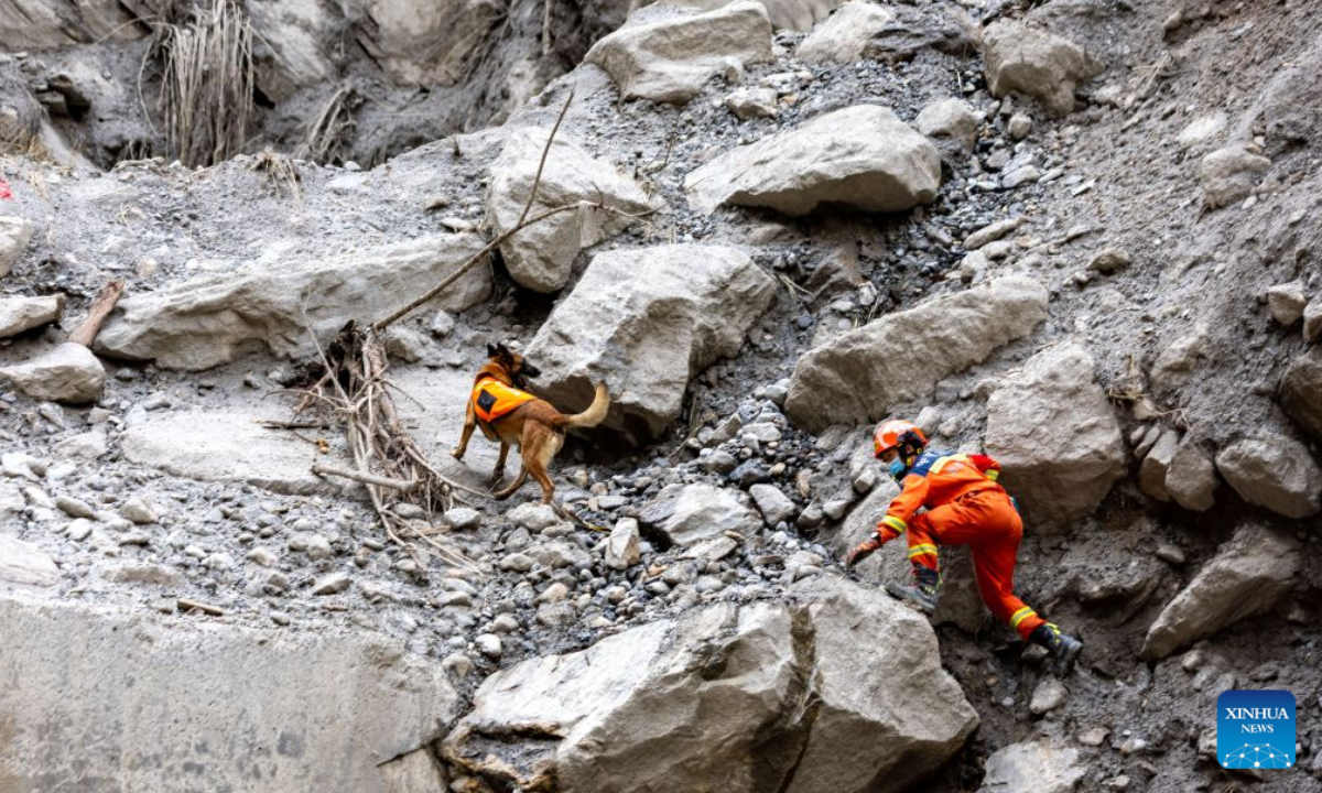 A rescuer and his sniffer dog search for the missing at the mudslide-hit area in Gyirong County, southwest China's Xizang Autonomous Region, Aug. 30, 2026. Rescuers are racing against time and the odds in search of survivors after a devastating mudslide, triggered by an ice-rock avalanche in Nepal, hit the border port of Gyirong in southwest China's Xizang Autonomous Region. (Xinhua/Jiang Fan)