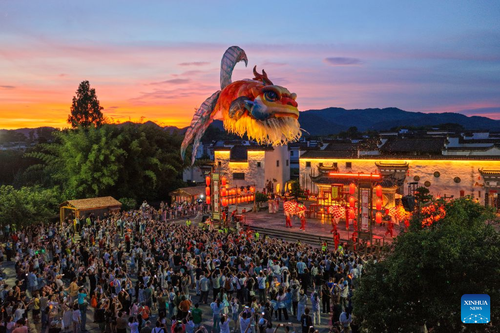 A drone photo shows a fish lantern parade staged in Tangmo Village of Huizhou District in Huangshan City, east China's Anhui Province, July 16, 2026.
Parade processions of the giant fish-shaped lantern meander through the streets in the ancient villages of Huangshan, creating a stunning spectacle at night. Many visitors came here to experience the parades, benefiting local tourism and related industries. (Photo by Shi Yalei/Xinhua)
