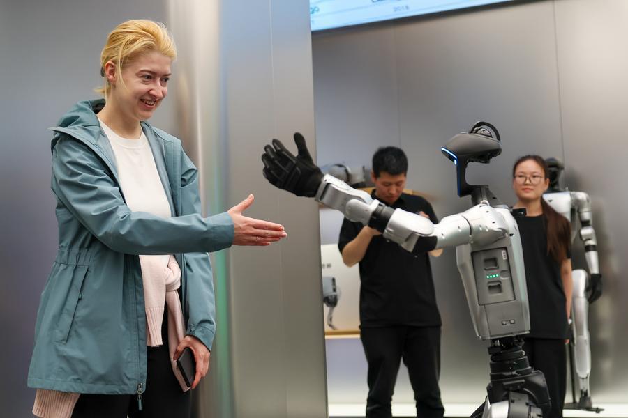 A Russian tourist interacts with a robot at a store of Unitree Robotics in Beijing, capital of China, April 30, 2026. (Xinhua/Ju Huanzong)