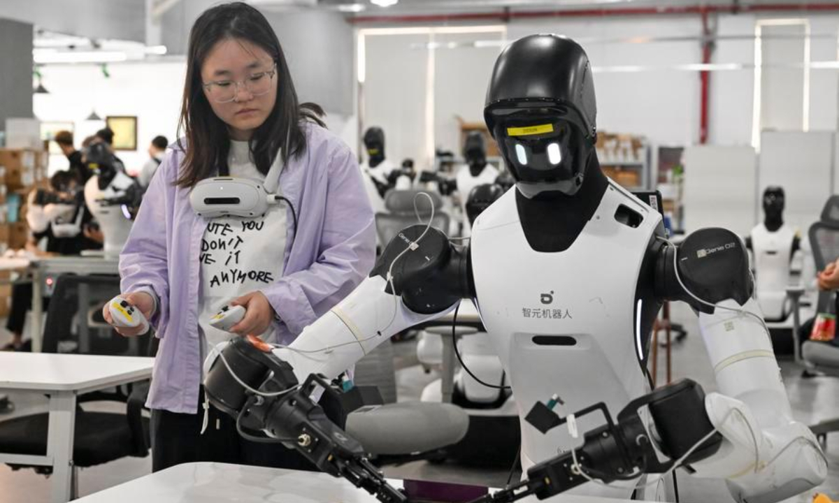A staff member trains a robot to work at a production line at Maniformer, a physical AI data service platform, in Shanghai, east China, Aug. 5, 2026. (Xinhua/Liu Ying)