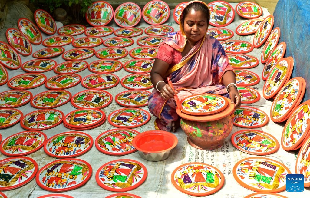 An artisan makes a traditional Lakshmi Sara in Munshiganj district, Bangladesh, Oct. 11, 2026. Lakshmi Sara is a round earthenware plate typically decorated with images of the Hindu goddess Lakshmi and other motifs and used in religious rituals. (Photo by Habibur Rahman/Xinhua)