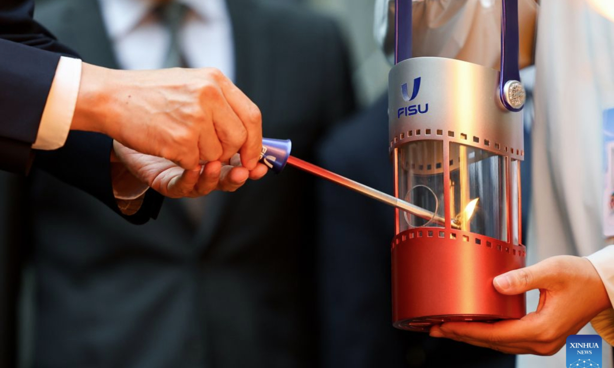The flame is collected to the flame lantern during the flame collection ceremony for the Changchun 2027 Winter Universiade in Turin, Italy, Oct. 8, 2026. (Xinhua/Wang Kaiyan)