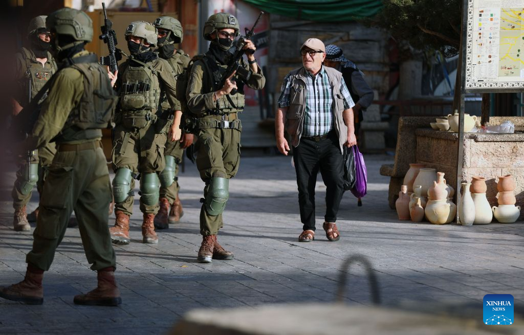 Members of Israeli forces secure the streets for Israeli settlers during a military raid in the Old City of Hebron, in the West Bank, Aug. 29, 2026. (Photo by Mamoun Wazwaz/Xinhua)