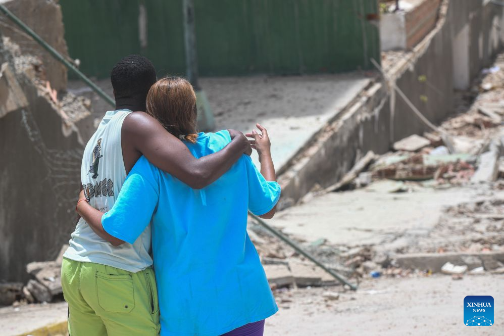 A couple embraces in front of a collapsed building in La Guaira State, Venezuela, June 25, 2026. Two powerful earthquakes, both exceeding magnitude 7, jolted Venezuela late Wednesday. Venezuela's acting President Delcy Rodriguez said the coastal state of La Guaira in northern Venezuela was the hardest hit, describing it as a 