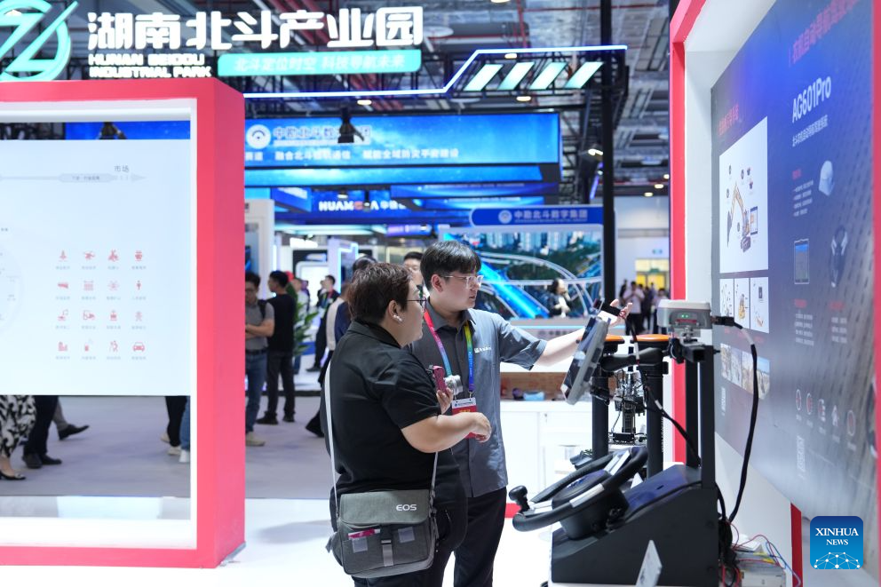 People learn about an autonomous navigating and steering system designed for farm machinery at the exhibition area of the 5th International Summit on BeiDou Navigation Satellite System (BDS) Applications in Zhuzhou, central China's Hunan Province, Sept. 15, 2026. The 5th International Summit on BDS Applications kicked off in Zhuzhou on Tuesday, attracting about 900 domestic and international experts, scholars, business leaders, government officials, and representatives of international organizations to its opening ceremony. (Xinhua/Chen Zhenhai)