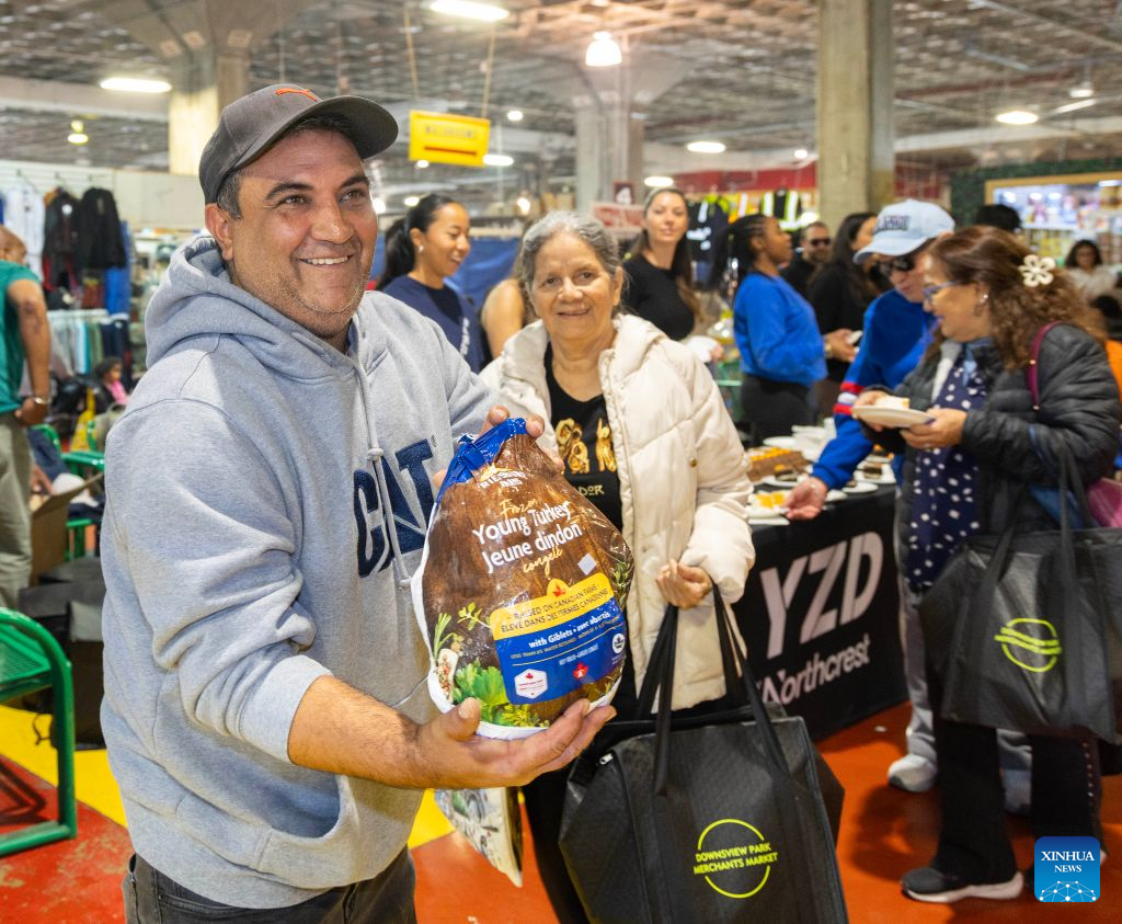 A man shows the free turkey he received at a farmers' market during the Thanksgiving Turkey Drive in Toronto, Canada, on Oct. 11, 2026. The annual event took place here on Sunday, providing 300 free turkeys for residents in need ahead of Canada's Thanksgiving Day, which falls on the second Monday of October each year. (Photo by Zou Zheng/Xinhua)