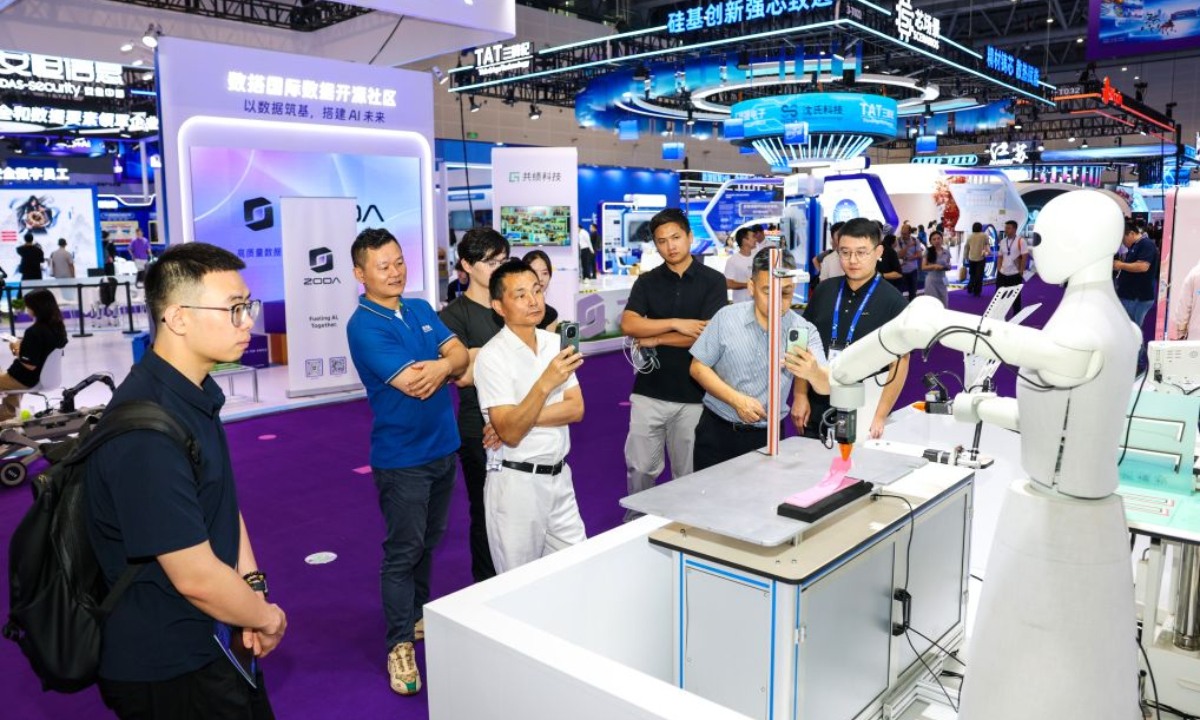 Visitors watch a robot demonstrating garment-making skills at the fifth Global Digital Trade Expo (GDTE) in Hangzhou, east China's Zhejiang Province, Sept. 24, 2026. (Xinhua/Jiang Han)