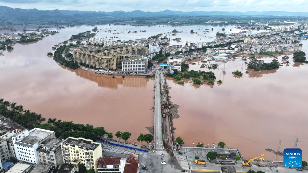 An aerial drone photo taken on Aug. 26, 2026 shows rescue vehicles deployed on a bridge removing flood debris in Ningming County, Chongzuo City, south China's Guangxi Zhuang Autonomous Region. Continuous heavy rainfall caused by Typhoon Narra, the 19th typhoon of the year, has swept across Ningming County. Local authorities have taken every efforts to clear, repair and reinforce the damaged roads and bridges. (Xinhua/Zhou Hua)