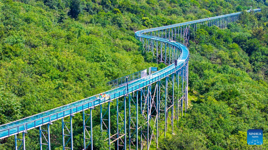 A drone photo taken on Aug. 2, 2026 shows tourists trying drifting at the Langya Mountain scenic area in Chuzhou, east China's Anhui Province. Located in the southwest of Chuzhou, the Langya Mountain scenic area is home to the renowned Zuiweng Pavilion, which was featured in a celebrated essay by Northern Song Dynasty literary figure Ouyang Xiu. In summer, the scenic area attracts visitors with daytime sightseeing and nighttime markets. (Photo by Ji Chengjun/Xinhua)