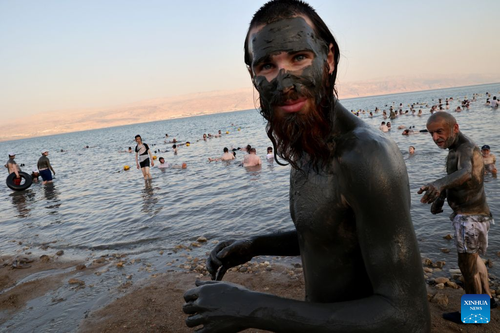 People cover themselves with mineral-rich mud at a Dead Sea resort, east of Jerusalem, Aug. 5, 2026. People visit the Dead Sea resort as high temperatures sweep across Israel and the Palestinian territories. (Photo by Gil Cohen Magen/Xinhua)