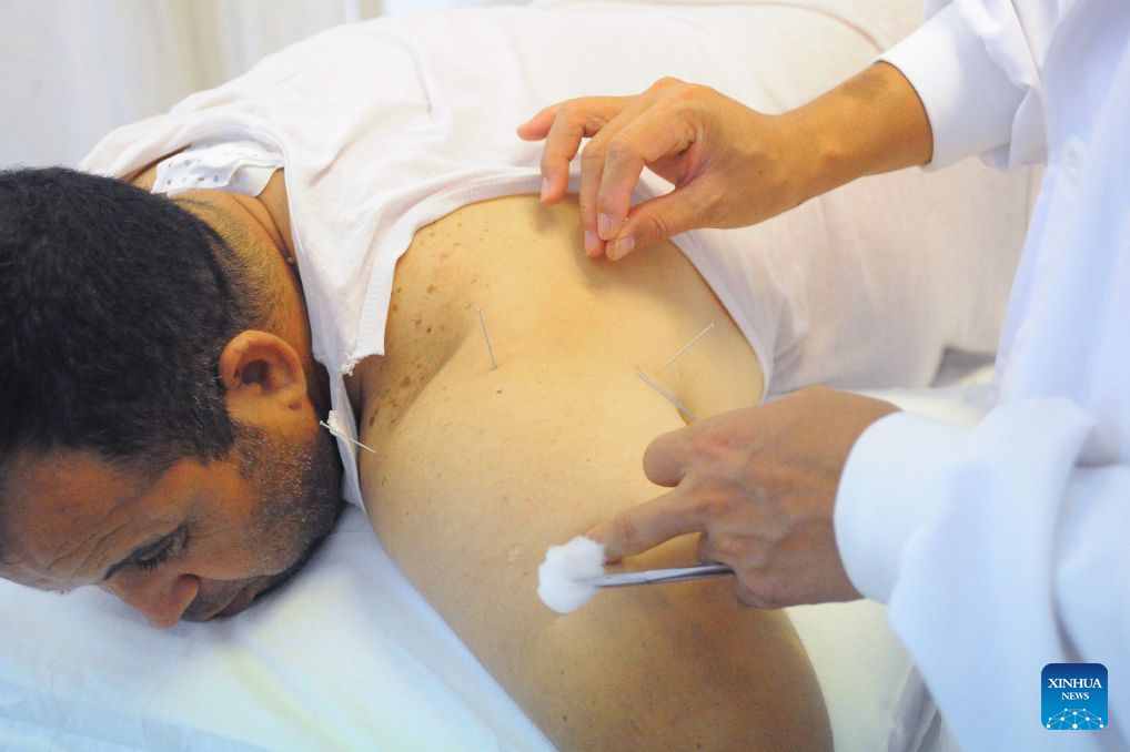 A doctor provides acupuncture treatment to a patient as a complement to Sanfutie, or Sanfu plaster, a centuries-old traditional Chinese medicine therapy, in Tunis, Tunisia, Aug. 14, 2026. The 30th Chinese medical team to Tunisia conducted Sanfutie treatments for the Tunisian people on Friday. (Photo by Adel Ezzine/Xinhua)