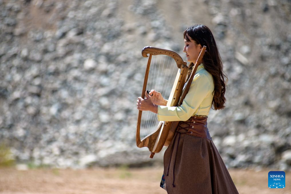 A woman plays a traditional musical instrument at a folk arts festival in the Bokonbaevo village at the south bank of the Issyk-Kul Lake, Kyrgyzstan, Aug. 1, 2026. (Xinhua)