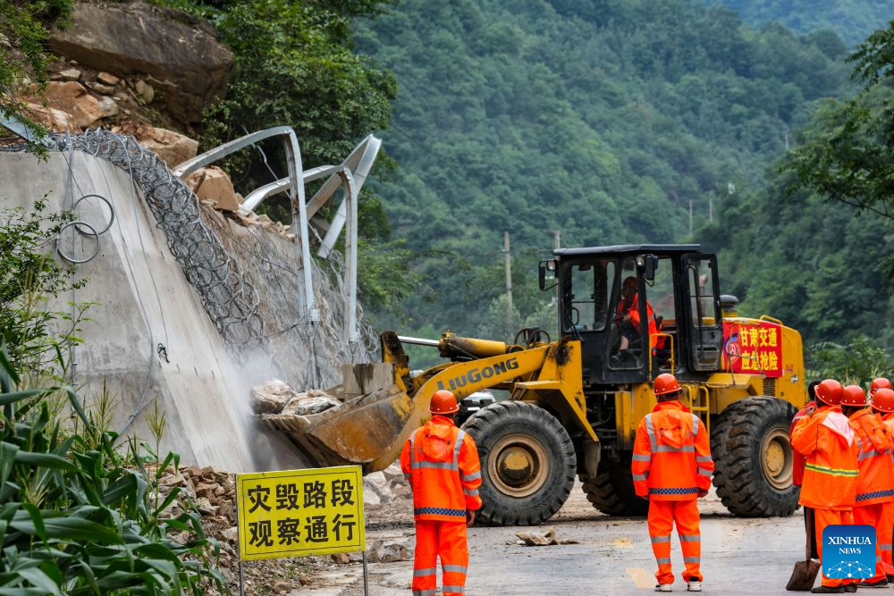 Staff members clear a road blocked by a landslide in Caoping Village of Fengxiang Township in Longnan, northwest China's Gansu Province, on Aug. 2, 2026. Longnan in northwest China's Gansu Province has activated Level II emergency response for flood control due to widespread heavy rainfall since Wednesday. Authorities at different levels have carried out inspections and assessments for potential hazards and repairs of damaged infrastructure, so as to safeguard people's lives and property. (Xinhua/Lang Bingbing)