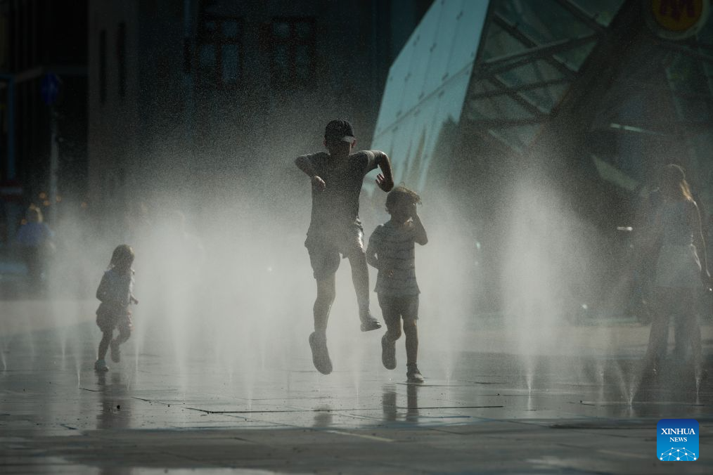 Children run in a splash pad to cool off in Warsaw, Poland, July 16, 2026. (Photo by Jaap Arriens/Xinhua)
