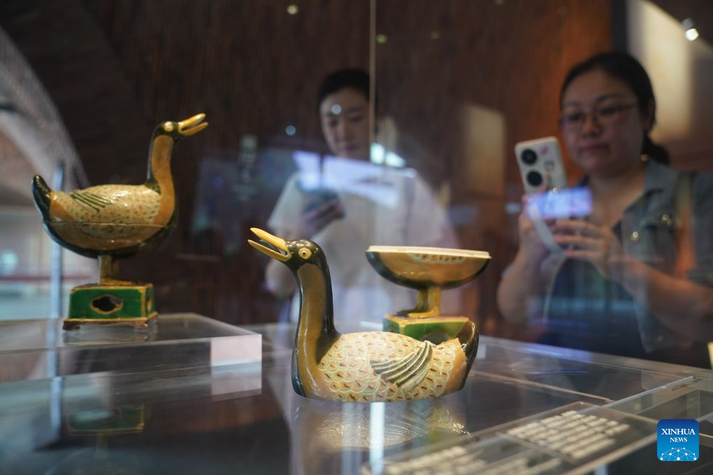 A visitor takes photos of duck-shaped ceramic incense burners at the Jingdezhen Imperial Kiln Institute in Jingdezhen, east China's Jiangxi Province, May 26, 2026. Featuring various museums, hands-on porcelain-making experiences, diverse ceramic art installations, and a slow-paced lifestyle, Jingdezhen has become a trendy destination for young tourists during the summer vacation. (Xinhua/Wan Xiang)