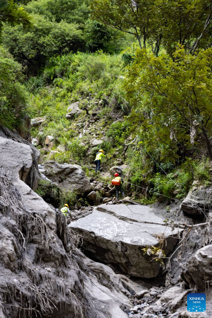 Communication support workers search for damaged optical cables at the mudslide-hit area in Gyirong County, southwest China's Xizang Autonomous Region, Aug. 30, 2026. A newly-built 4G/5G base station, approximately 900 meters from the mudslide-hit Gyirong Port in Gyirong County, was put into use on Sunday, ensuring more stable communication signals at the core rescue site. (Xinhua/Jiang Fan)