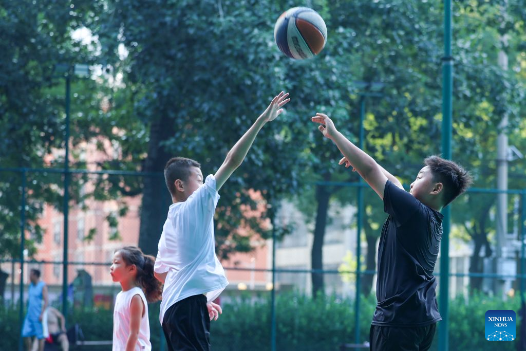 Children play basketball at a park in Shijiazhuang, north China's Hebei Province, Aug. 6, 2026. On the occasion of National Fitness Day, a legacy of the 2008 Beijing Olympics, more people are embracing active lifestyles. (Photo by Liang Zidong/Xinhua)