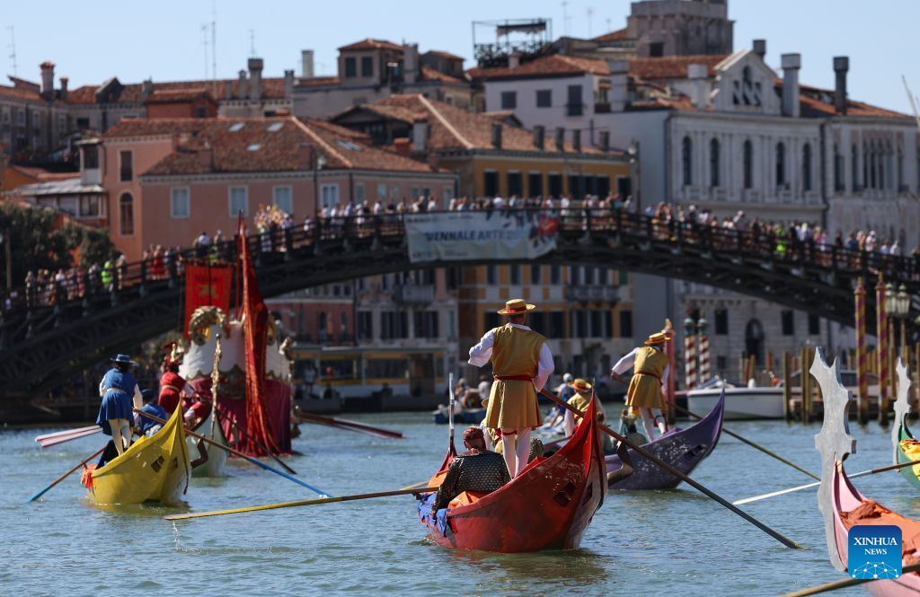 People sail past the Accademia Bridge in the Regata Storica boat race in Venice, Italy, Sept. 6, 2026. The Regata Storica is a historic annual boat parade and rowing race on the Grand Canal in Venice. (Xinhua/Wang Kaiyan)