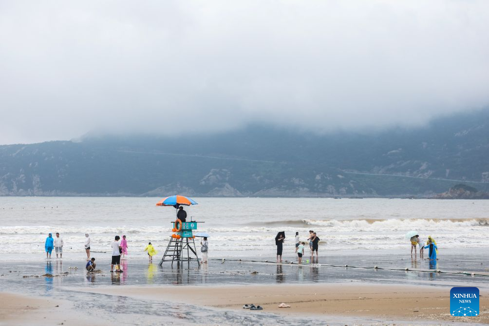 People have fun at the Nansha scenic area in Zhujiajian of Zhoushan City, east China's Zhejiang Province, Aug. 12, 2026.
The Nansha scenic area reopened to the public on Wednesday following necessary safety checks and maintenance after Typhoon Dolphin weakened. (Xinhua/Xu Yu)