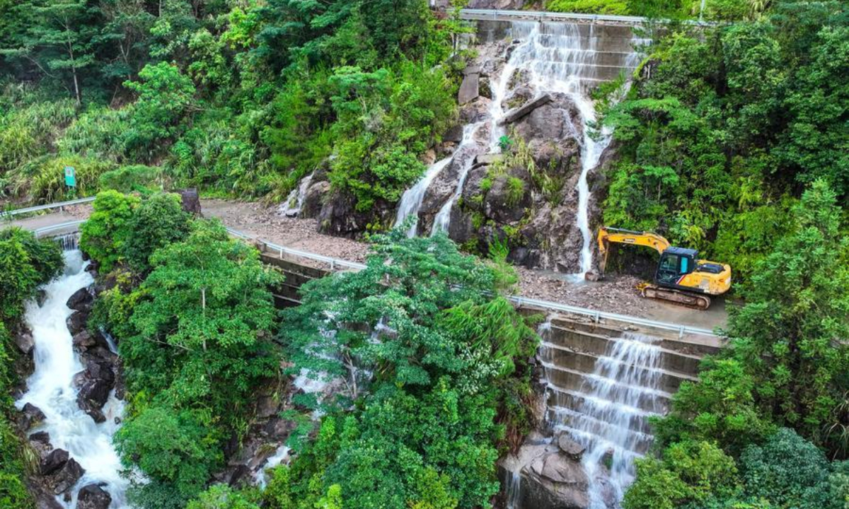 An aerial drone photo taken on Aug. 10, 2026 shows an excavator carrying out emergency repairs on a mountain road blocked by a landslide in Yongjia County in Wenzhou, east China's Zhejiang Province. (Xinhua/Jiang Han)