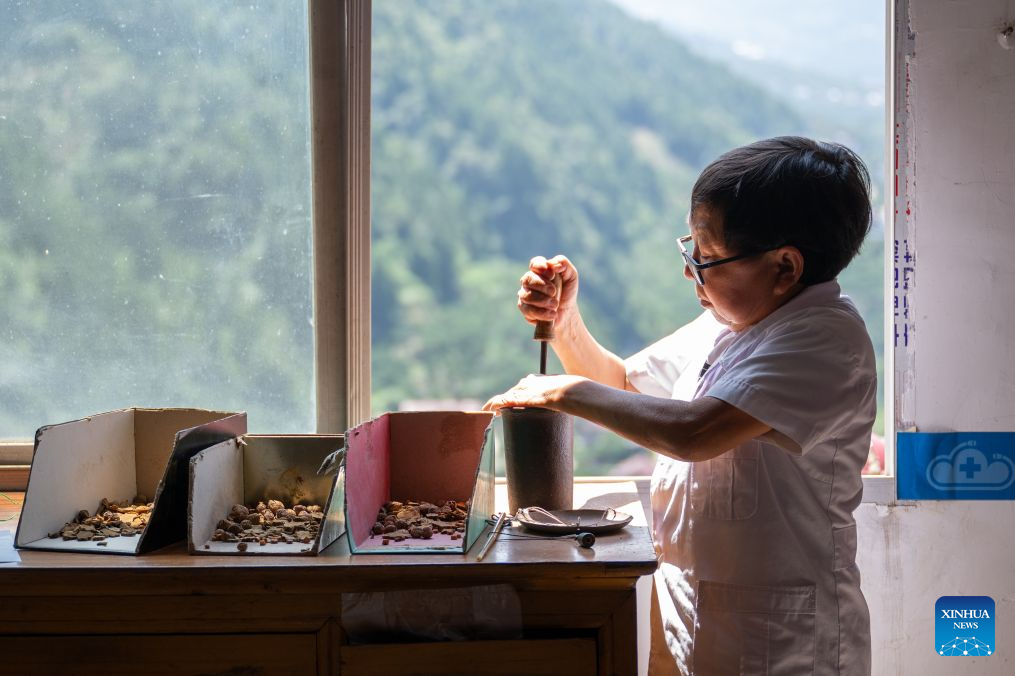 Wang Ju prepares herbal medicine in Lianghe Village, Lianghekou Town, Zigui County of Yichang, central China's Hubei Province, Aug. 15, 2026. Wang Ju, a 59-year-old village doctor in Lianghe Village of Lianghekou Town in Zigui County, has spent nearly four decades providing health care for the entire village, despite standing just 1.28 meters tall and weighing only 32 kilograms due to dwarfism.
In his youth, he was cared for by fellow villagers, which inspired him to study medicine and give back to his community. After graduating from a health school, he returned to the village to take on basic medical care and health services.
Homes in Lianghe Village are scattered across the mountains and roads are rugged. Initially, Wang made house calls barely on foot. Later he commissioned a specially downsized motorcycle with a frame only 50 centimeters high, tailored to his stature.
Over the past 38 years, Wang has made over 6,000 home visits, with four such motorcycles and more than 100 pairs of shoes worn out. For him, being a doctor is not just a profession, but a daily commitment to safeguarding the health of the people who once took care of him. (Xinhua/Du Zixuan)