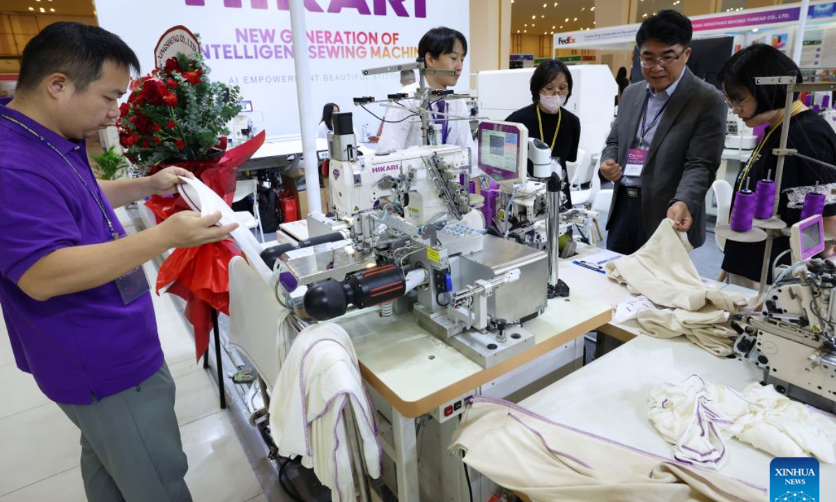 People look at sewing machines during an international industrial expo in Phnom Penh, Cambodia, Aug. 15, 2026. A wide variety of advanced Chinese tech and manufacturing firms showcased cutting-edge machinery, automation, and innovative production solutions at a major international industrial exhibition here in Cambodia's capital. (Photo by Sovannara/Xinhua)