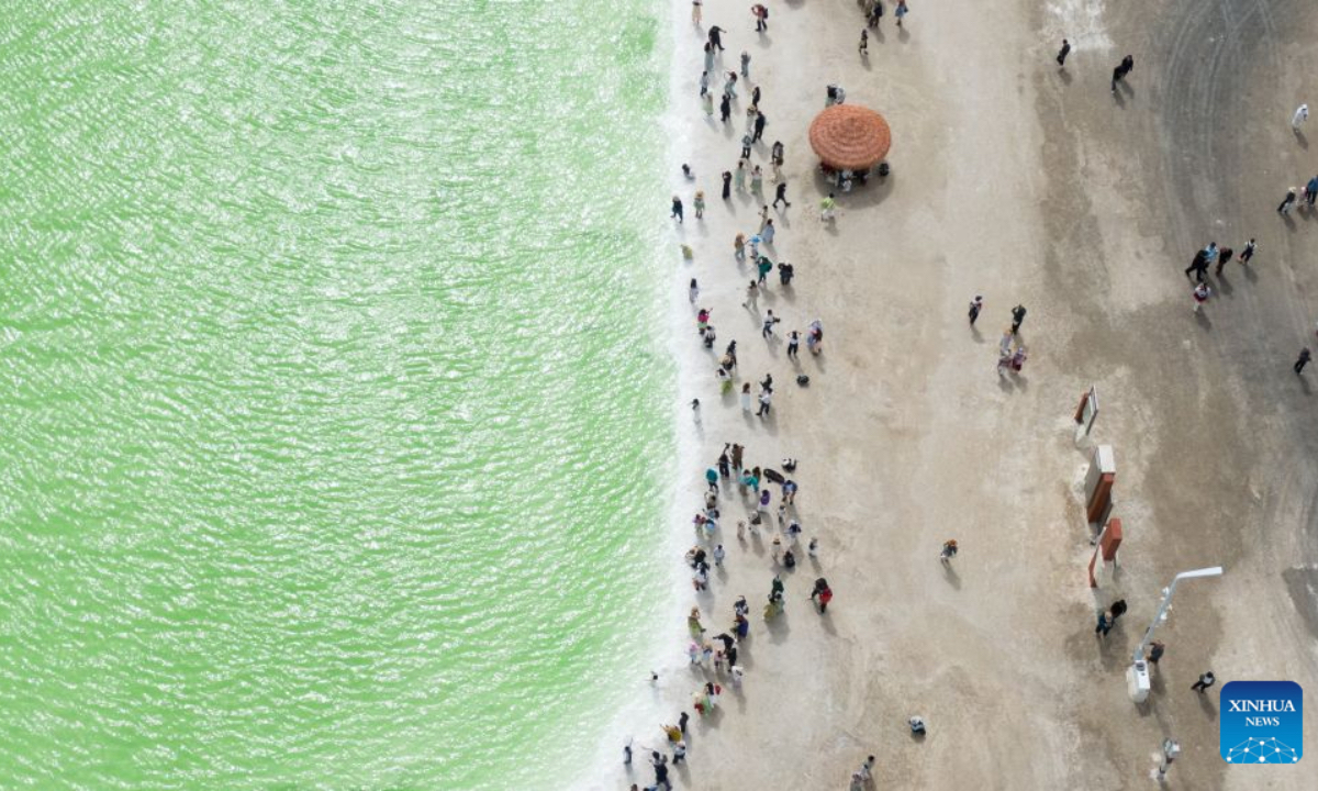 An aerial drone photo taken on July 9, 2026 shows tourists visiting the Qairhan salt lake in Golmud, northwest China's Qinghai Province. The Qairhan salt lake, with a total area of 5,856 square kilometers, has been the largest potash fertilizer producing base in China. (Xinhua/Wang Yan)