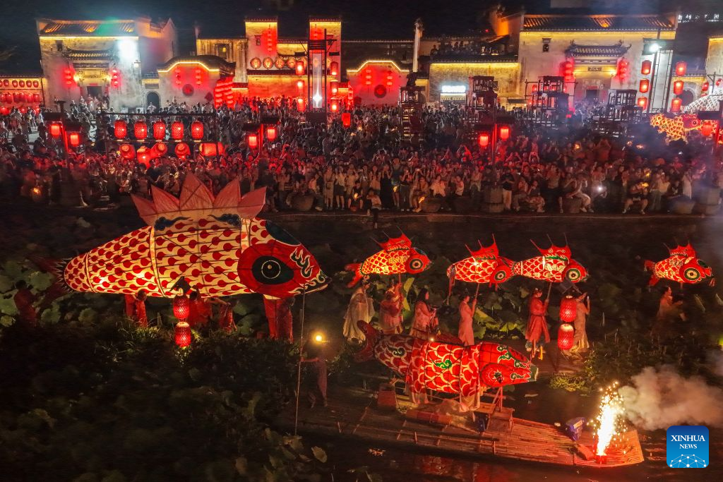 A drone photo shows a fish lantern parade staged in Chengkan Village of Huizhou District in Huangshan City, east China's Anhui Province, Aug. 3, 2026.
Parade processions of the giant fish-shaped lantern meander through the streets in the ancient villages of Huangshan, creating a stunning spectacle at night. Many visitors came here to experience the parades, benefiting local tourism and related industries. (Photo by Shi Yalei/Xinhua)
