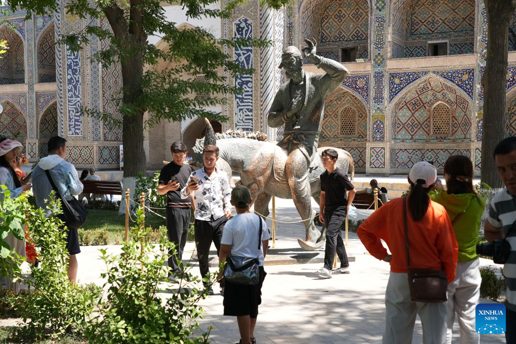 Tourists take photos around the Statue of Hodja Nasreddin in Bukhara, Uzbekistan, Aug. 3, 2026. The historic city of Bukhara in southwestern Uzbekistan is currently gripping with severe heat, with daytime highs consecutively exceeding 35 degrees Celsius. (Photo by Zafar Khalilov/Xinhua)