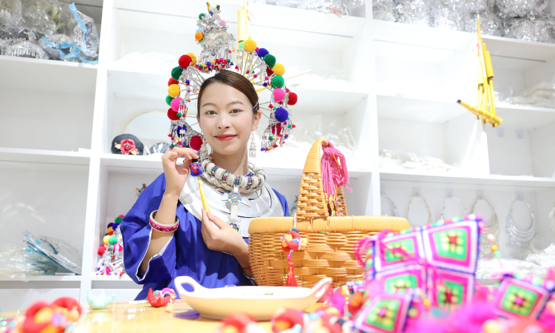 A young woman displays a traditional sachet, included in the county-level intangible cultural heritage list, in a clothing store in Guyi township, South China's Guangxi Zhuang Autonomous Region, on June 18, 2026. Photo: VCG